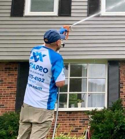 Worker spraying a house and cleaning it