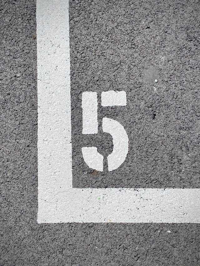 Number 5 stenciled on concrete.