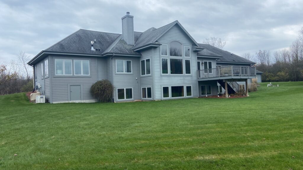 Back yard view of a house with gleocapsa magma. This roof cleaning in Grafton took place late in the year.